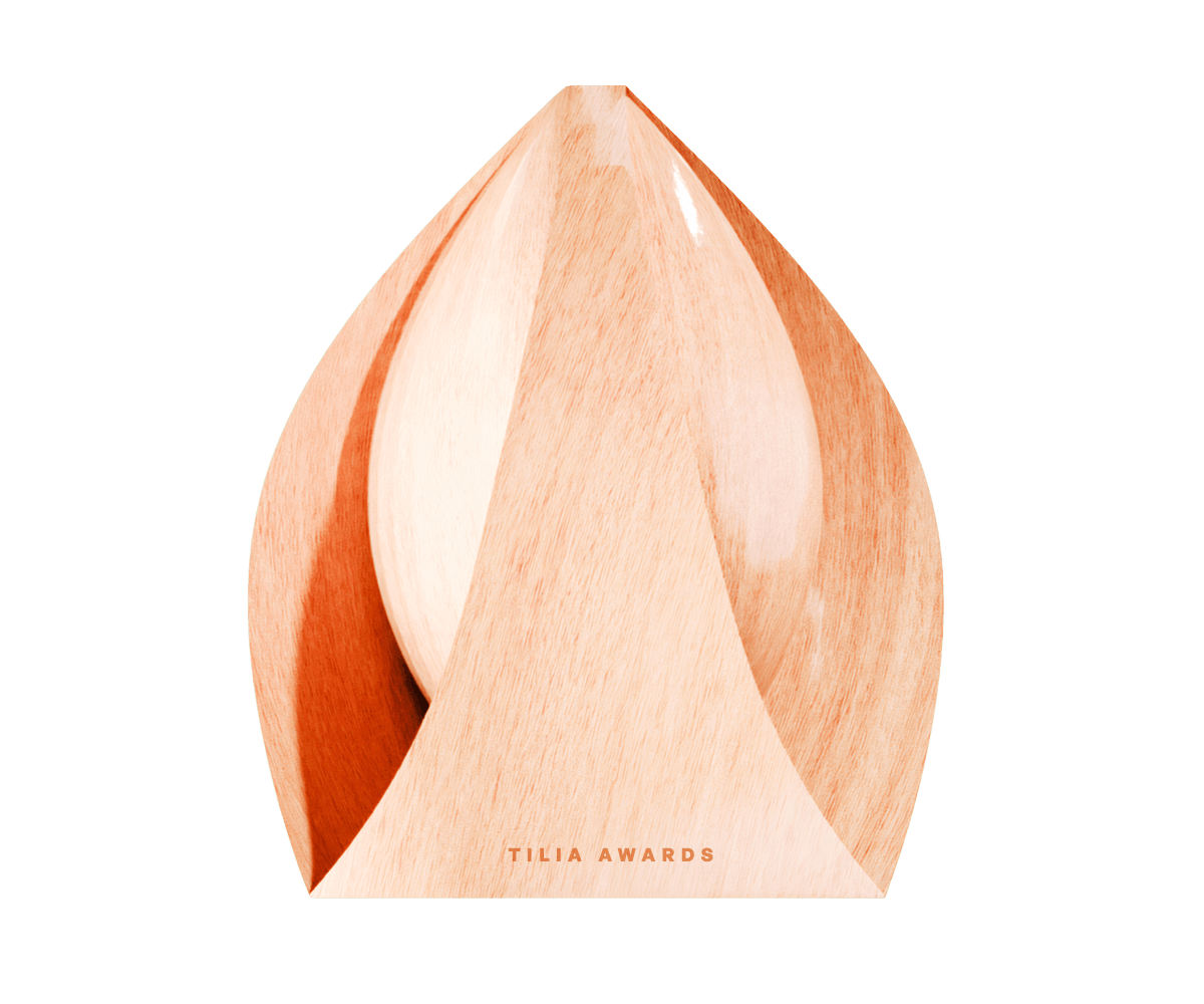 Holzene Trophäe in Form einer stilisierten Blüte mit der Gravur "TILIA AWARDS" an der Basis.